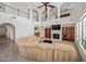 Spacious living room featuring a fireplace, bar and custom shelving, perfect for entertaining or relaxing at 19242 W Pasadena Ave, Litchfield Park, AZ 85340