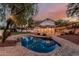 Twilight view of a backyard with pool, patio, and string lights enhancing the outdoor ambiance at 20412 W Thayer St, Buckeye, AZ 85396