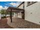 Relaxing backyard patio with a covered pergola, mature trees, and brick flooring at 20412 W Thayer St, Buckeye, AZ 85396