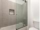 Tiled shower and tub combination with glass doors and mosaic tile details at 20412 W Thayer St, Buckeye, AZ 85396