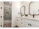 Dual sink bathroom with black faucets, framed mirrors, and a shower/tub combo at 20412 W Thayer St, Buckeye, AZ 85396