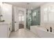 Bathroom with a walk-in shower, soaking tub, and white marble surround for a luxurious experience at 20412 W Thayer St, Buckeye, AZ 85396