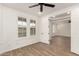 A spacious bedroom with hard flooring, white shutters, and ceiling fan at 20412 W Thayer St, Buckeye, AZ 85396