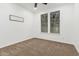 A bedroom with carpeted floors, white walls, and two double-hung windows for natural light at 20412 W Thayer St, Buckeye, AZ 85396