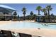 Zero entry community pool with lounge chairs, umbrellas, and palm trees providing shade at 20412 W Thayer St, Buckeye, AZ 85396