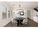 Bright dining room with wainscoting, large windows, a modern chandelier, and a dark wood table and chairs at 20412 W Thayer St, Buckeye, AZ 85396
