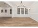 Spacious dining room featuring a modern chandelier, plantation shutters, and hard wood flooring at 20412 W Thayer St, Buckeye, AZ 85396