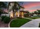 Two-story home with a covered front porch, lush lawn, and mature tree at 20412 W Thayer St, Buckeye, AZ 85396