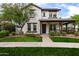 Inviting two-story home featuring a covered porch, a meticulously maintained lawn, and a paved walkway at 20412 W Thayer St, Buckeye, AZ 85396