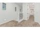 Hallway with a carpeted floor, white walls, and a decorative railing at the top of the stairwell at 20412 W Thayer St, Buckeye, AZ 85396