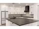 Modern kitchen with white cabinets, black countertops, and stainless steel appliances at 20412 W Thayer St, Buckeye, AZ 85396