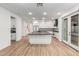 Spacious kitchen featuring an island, white cabinets, dark countertops, and wood-look tile flooring at 20412 W Thayer St, Buckeye, AZ 85396