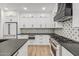 Modern kitchen featuring white cabinets, black countertops, patterned backsplash, and stainless steel appliances at 20412 W Thayer St, Buckeye, AZ 85396