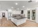 Bright open kitchen with a large island, white cabinets, dark countertops, and stainless steel appliances at 20412 W Thayer St, Buckeye, AZ 85396