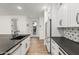 Bright kitchen with white cabinets, black countertops, a large island, and stainless steel appliances at 20412 W Thayer St, Buckeye, AZ 85396