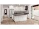 Open kitchen features white cabinets, black countertops, stainless appliances, and a large central island at 20412 W Thayer St, Buckeye, AZ 85396