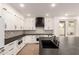 Well-lit kitchen featuring white cabinets, black countertops, and decorative backsplash and stainless steel appliances at 20412 W Thayer St, Buckeye, AZ 85396