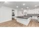 Open kitchen with a large island, white cabinets, dark countertops, and wood-look tile flooring at 20412 W Thayer St, Buckeye, AZ 85396