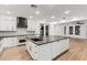 Open-concept kitchen with a large island, white cabinets, dark countertops, and stainless steel appliances at 20412 W Thayer St, Buckeye, AZ 85396