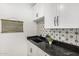 Charming laundry room with black granite counters, decorative backsplash, and modern finishes at 20412 W Thayer St, Buckeye, AZ 85396
