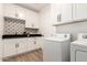 Clean laundry room with white cabinets, granite countertops, and modern tiling at 20412 W Thayer St, Buckeye, AZ 85396