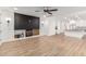 Open-concept living room with a fireplace, wood-look tile flooring, and access to the kitchen at 20412 W Thayer St, Buckeye, AZ 85396