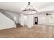 Spacious living room with wood floors, iron railing staircase, and open layout to other rooms at 20412 W Thayer St, Buckeye, AZ 85396