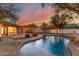Inviting backyard pool with brick trim and string lights creates a warm and relaxing outdoor space at 20412 W Thayer St, Buckeye, AZ 85396