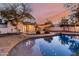 Backyard scene at dusk with a pool reflecting string lights, and outdoor patio space at 20412 W Thayer St, Buckeye, AZ 85396