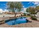 A backyard oasis showcasing a refreshing pool, mature trees, and lush landscaping at 20412 W Thayer St, Buckeye, AZ 85396