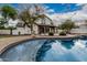 Resort-style backyard featuring a pool, mature trees, outdoor kitchen, and patio at 20412 W Thayer St, Buckeye, AZ 85396