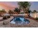 Picturesque backyard pool area with brick surround and soft lighting at dusk at 20412 W Thayer St, Buckeye, AZ 85396
