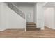 Bright foyer featuring a staircase with decorative iron railing and wood flooring at 20412 W Thayer St, Buckeye, AZ 85396