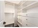Bright walk-in closet with built-in shelving and drawers with silver hardware at 20412 W Thayer St, Buckeye, AZ 85396