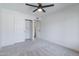 Clean bedroom with white walls, neutral carpet, ceiling fan, and closet at 2309 W Naranja Ave, Mesa, AZ 85202