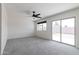 Bright living room with sliding glass door, neutral carpet, and modern ceiling fan at 2309 W Naranja Ave, Mesa, AZ 85202