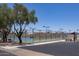 View of outdoor tennis courts with a fence and shade trees at 2309 W Naranja Ave, Mesa, AZ 85202