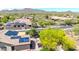 Panoramic aerial showcasing neighborhood with solar panels on roofs and manicured landscaping against a mountain backdrop at 2405 W Memorial Dr, Anthem, AZ 85086