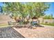 Backyard patio features a brick surface, shaded seating beneath a tree, and a porch swing at 2405 W Memorial Dr, Anthem, AZ 85086