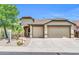 Inviting single-story home showcasing a well-kept xeriscaped front yard and a convenient three-car garage at 2405 W Memorial Dr, Anthem, AZ 85086