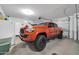 Clean and well-lit garage featuring an orange truck, white fridge, and convenient garage door opener at 2405 W Memorial Dr, Anthem, AZ 85086