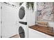 Bright laundry area featuring a modern stacked washer and dryer with door to outside at 2405 W Memorial Dr, Anthem, AZ 85086