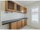 Laundry room with oak cabinets, laminate countertop, and a window overlooking the backyard at 2605 E Fountain St, Mesa, AZ 85213