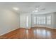 Bright living room featuring hardwood floors, a ceiling fan and a large window with plantation shutters at 2605 E Fountain St, Mesa, AZ 85213