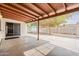 Covered patio with concrete flooring overlooking a large backyard with mature trees at 2605 E Fountain St, Mesa, AZ 85213