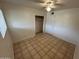 Bright bedroom with a ceiling fan, tiled floor, closet, and white door at 3062 N 42Nd Ave, Phoenix, AZ 85019