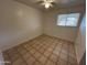 Well-lit bedroom featuring a ceiling fan, tiled floors, and a window with blinds for natural light at 3062 N 42Nd Ave, Phoenix, AZ 85019