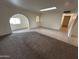 Bright living room with carpet and tile flooring, skylight, and arched doorway to other rooms at 3062 N 42Nd Ave, Phoenix, AZ 85019