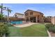 Expansive backyard features a refreshing pool, manicured turf, and a putting green at 4323 E Dublin St, Gilbert, AZ 85295