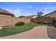 Backyard with putting green, brick pavers, block wall, and desert landscaping creating a private outdoor space at 4323 E Dublin St, Gilbert, AZ 85295